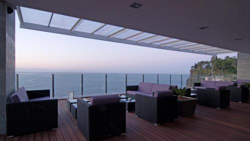 a balcony with chairs and a view of the ocean at Pestana Carlton Madeira Ocean Resort Hotel in Funchal