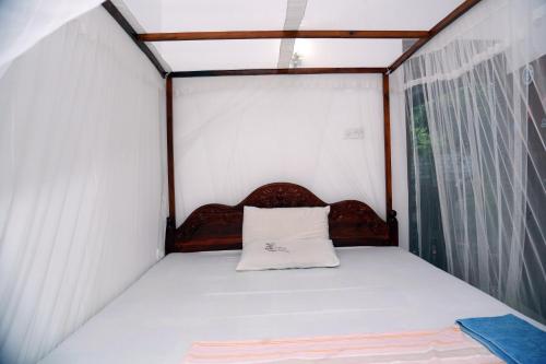 a small bed in a room with a window at Gihan Guesthouse in Mirissa