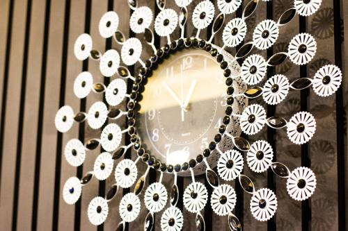 a clock with white flowers on a wall at Yeosu Thestay Hostel in Yeosu
