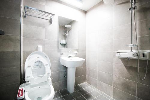 a bathroom with a toilet and a sink at Yeosu Thestay Hostel in Yeosu