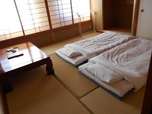 A bed or beds in a room at New Central Hotel Katsuta