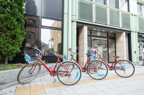three bikes parked in front of a building at Hotel Iidaya in Matsumoto