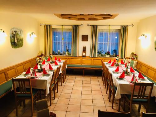 una habitación con mesas largas con servilletas rojas. en Landhaus Schönfelder Hof, en Hollfeld