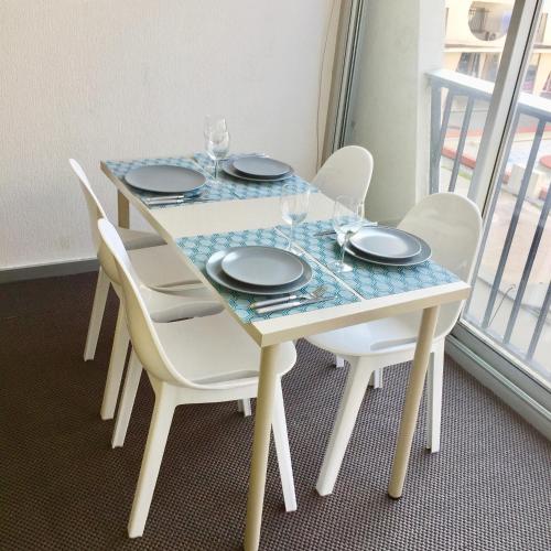une table avec des chaises, des assiettes et des verres dans l'établissement Studio sur le port, à La Grande Motte