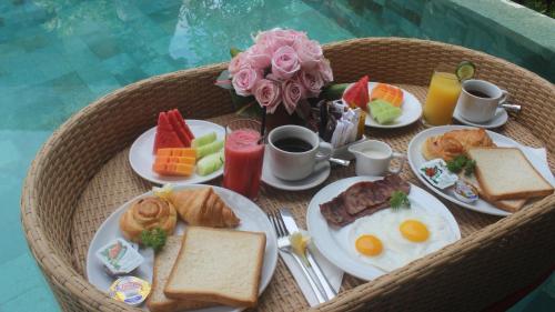 Una mesa con platos de comida para el desayuno. en Mahagiri Villas & Spa Dreamland, en Uluwatu