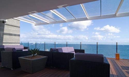 a balcony with chairs and a view of the ocean at Pestana Carlton Madeira Ocean Resort Hotel in Funchal