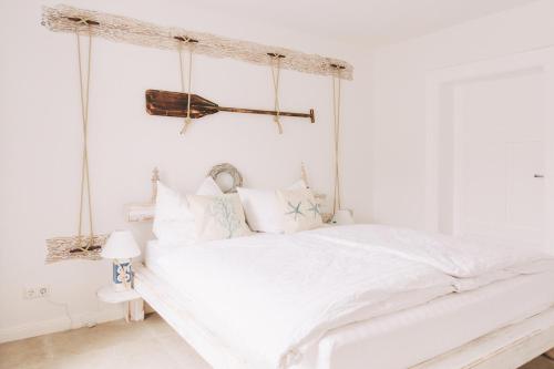 a white bedroom with a white bed with a canopy at Haus Vicus in Greifswald