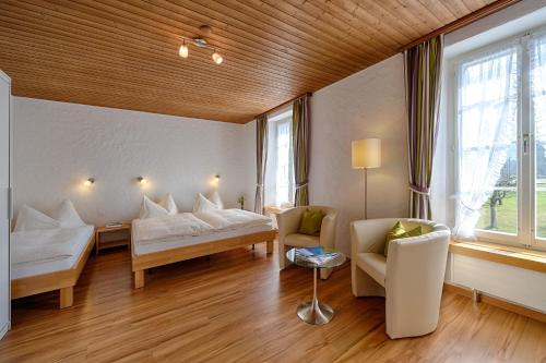 a living room with two beds and a couch at Neuhaus Golf- & Strandhotel in Interlaken