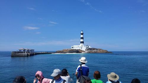 a group of people looking at a lighthouse on an island at Beachcastle & Sea View Villa in Magong