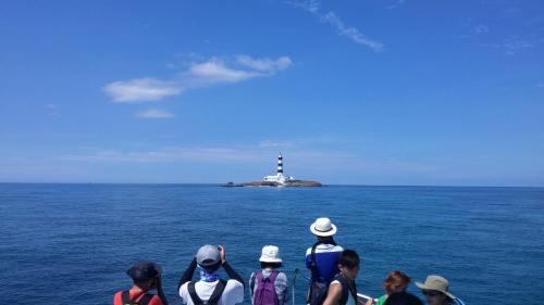 a group of people on a boat in the ocean with a lighthouse at Beachcastle & Sea View Villa in Magong