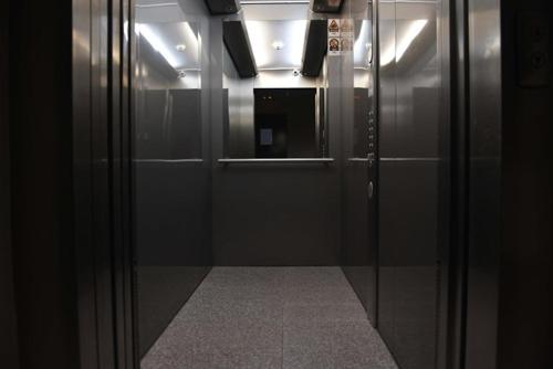 a hallway with a glass door in a elevator at Oaza Apartman Zagreb Arena 1 in Zagreb