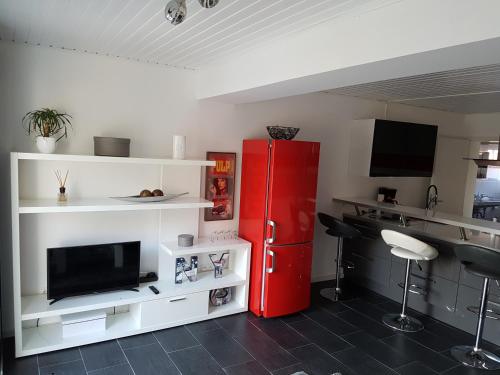 a kitchen with a red refrigerator and white shelves at Häuslinger Ferienwohnung in Erlangen