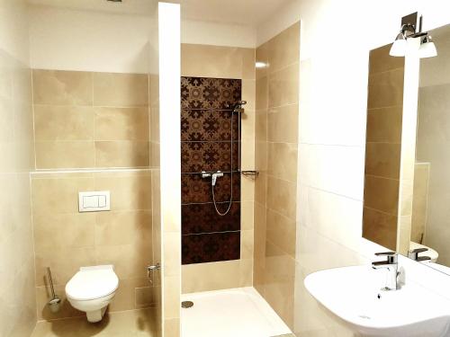 a bathroom with a shower and a toilet and a sink at Hotel Dvůr in Krnsko
