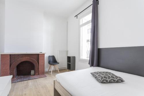 une chambre avec un lit et une cheminée dans l'établissement Gare Saint Roch - Podshare, à Montpellier