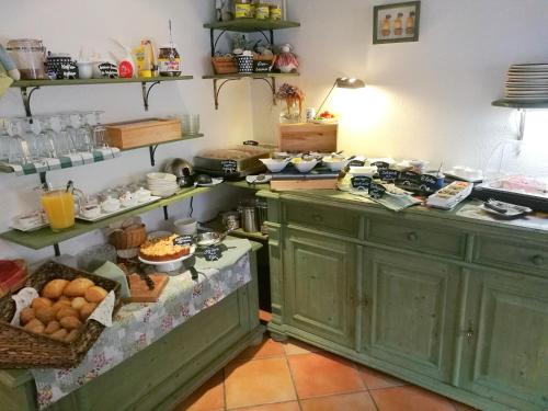 a kitchen with green cabinets and lots of food at Elbhangzimmer Dresden in Dresden