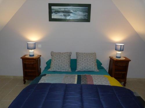 a bedroom with a blue bed with two night stands at Les Gîtes Bleus de Lannion - avec cuisine- in Lannion