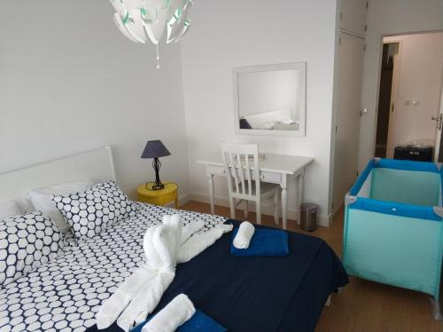 a bedroom with a bed and a table with a chair at Lila's Beach Apartment in São Roque