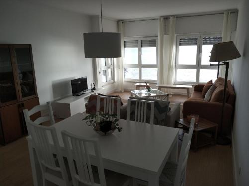 a living room with a white table and chairs at Lila's Beach Apartment in São Roque