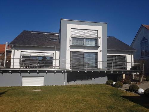 a large white house with a large deck at Häuslinger Ferienwohnung in Erlangen