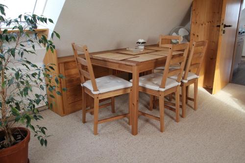 a wooden table with four chairs and a table and a plant at Ferienwohnung Hamberge in Hamberge