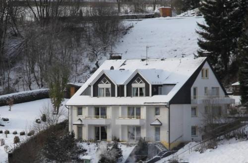 a white house with snow on top of it at Appartementhaus Vierjahreszeiten in Willingen