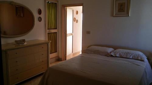 um quarto com uma cama, uma cómoda e um espelho em attico centro mattinata em Mattinata