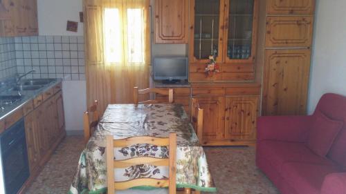 uma cozinha com uma mesa e um sofá vermelho em attico centro mattinata em Mattinata