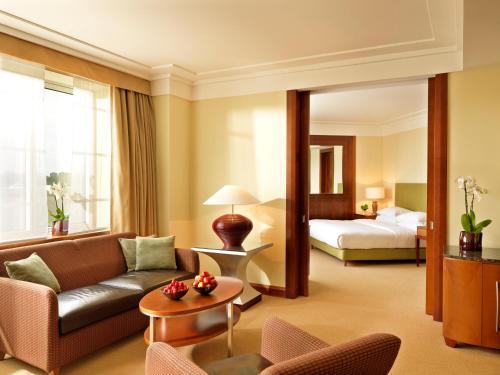 a hotel room with a couch and a bed at Regent Warsaw Hotel in Warsaw