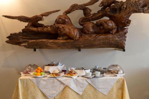 a table with food on it with a statue on the wall at Hotel La Cascata in Azzano San Paolo