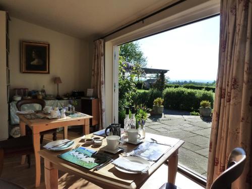 a dining room with a table and a large window at The Lodge, at Orchard Cottage in Much Marcle
