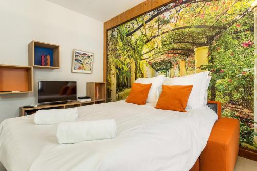een slaapkamer met een groot wit bed met oranje kussens bij Apartment La Maisonnee in Chamonix-Mont-Blanc