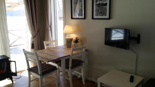 ウッラレッドにあるSjönära Ullaredのダイニングルームテーブル(椅子付)、壁掛けテレビが備わります。