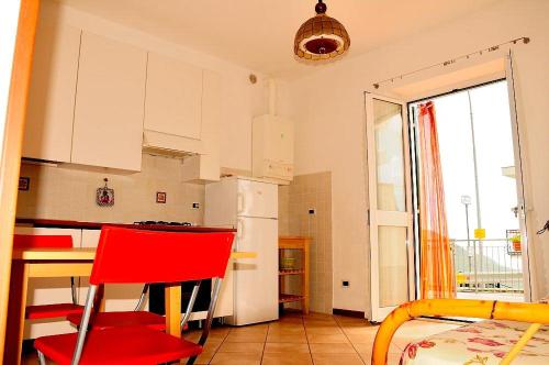 una cucina con sedia rossa e frigorifero bianco di La Casa Gialla a Moneglia