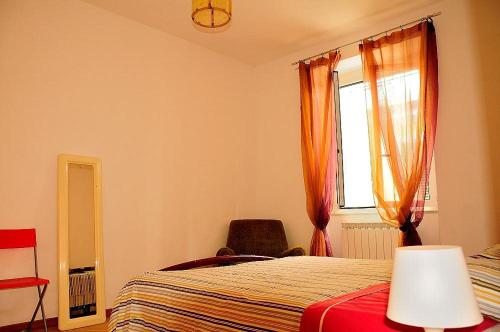 una camera da letto con un letto, una finestra e una sedia di La Casa Gialla a Moneglia
