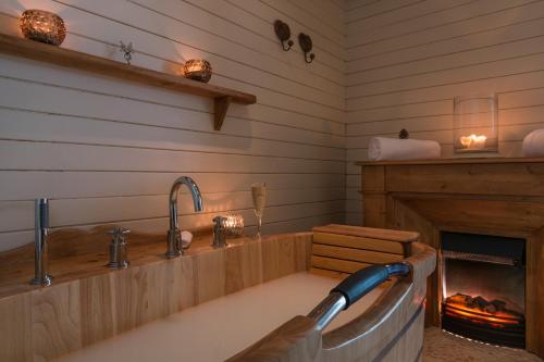 
a bath room with a tub and a fire place at Hotel Au Chamois d'Or in L'Alpe-d'Huez
