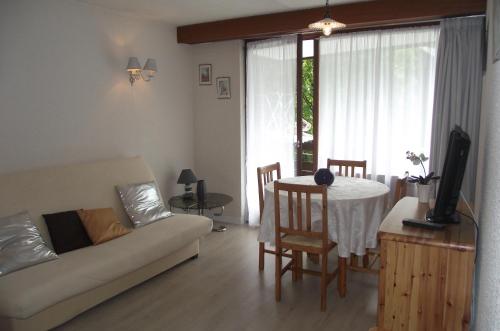 un salon avec une table et un canapé dans l'établissement Appartement les Domes, à Le Mont-Dore