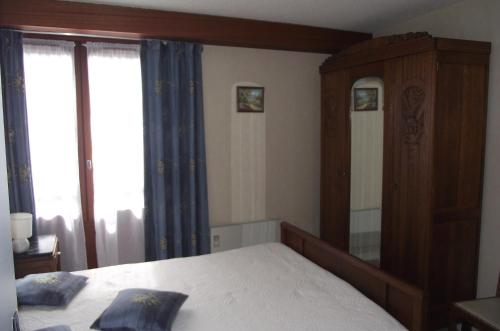 une chambre avec un lit et un grand miroir dans l'établissement Appartement les Domes, à Le Mont-Dore