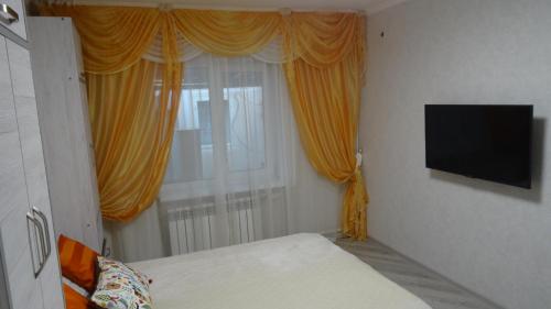 ゲレンジークにあるGuest House on Priboynaya 6のベッドルーム1室(ベッド1台付)、黄色いカーテン付きの窓が備わります。