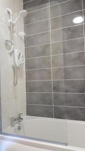 a bathroom with a shower and a bath tub at The Ship Inn in Bardsea