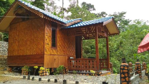 uma pequena casa de bambu com um grande deque em Riverside Nature Bungalow - Namo Samsah Jungle Paradise em Bukit Lawang