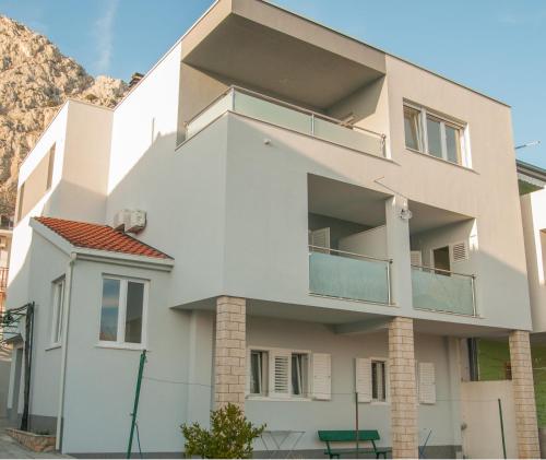 ein weißes Gebäude mit Balkon auf der Seite in der Unterkunft Apartments Vulić in Omiš