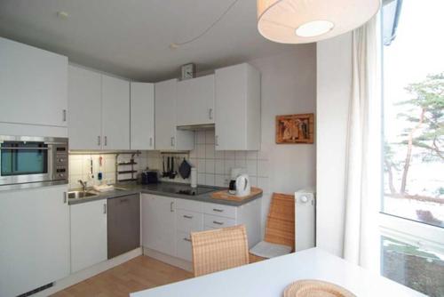 eine Küche mit weißen Schränken und einem großen Fenster in der Unterkunft Villa Strandperle, Whg. 10 in Bansin