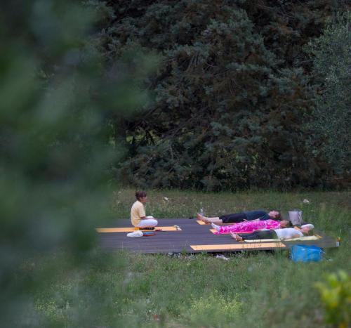 a group of people laying on picnic tables in a field at Hotel Santo Stefano in Portoferraio