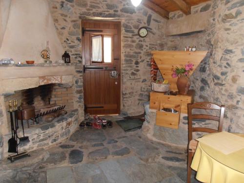 a stone room with a fireplace and a wooden door at Neromylos in Agia Pelagia