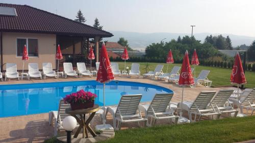 a group of chairs and umbrellas next to a pool at Вилен комплекс Дарибел in Sapareva Banya