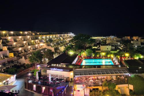 a view of a city at night with a swimming pool at CapSexy Port Nature Waiki Naturist Village in Cap d'Agde
