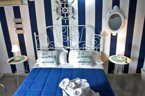 a bedroom with a blue and white striped wall at Oasi Del Gabbiano in Siracusa