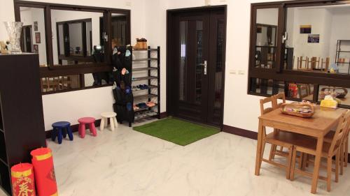 a room with a table and chairs and a door at Home of 120 B&B in Jiaoxi
