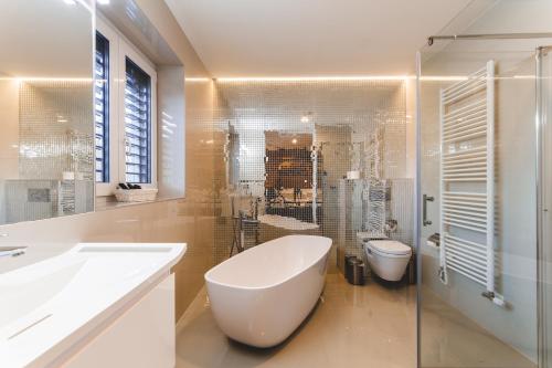a bathroom with a white tub and a toilet at SILESIA Residence in Ostrava