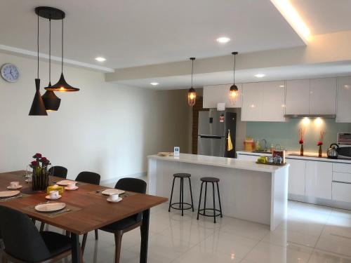a kitchen and dining room with a table and chairs at Teega Residence @ Cosy Seafront Living in Nusajaya